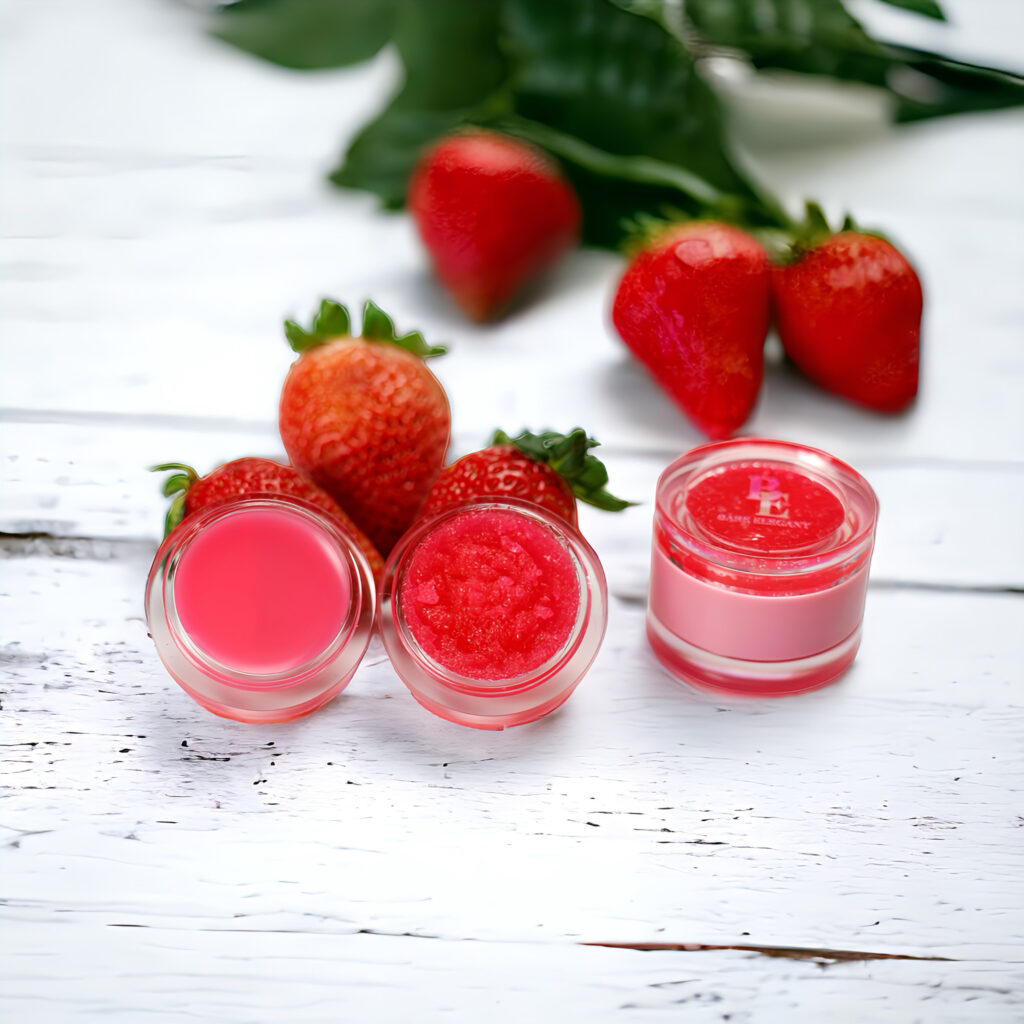 Three small jars of red lip balm with fresh strawberries on a white wooden surface.