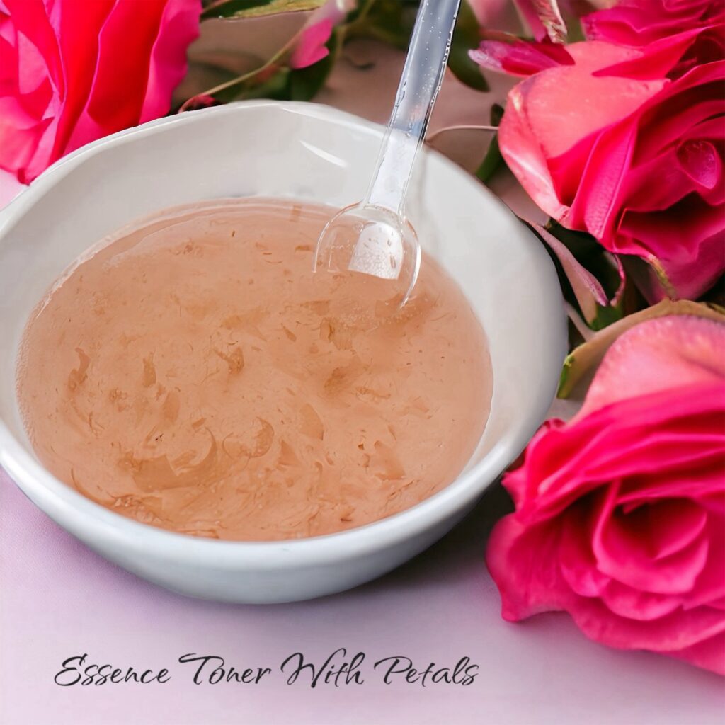 A bowl of essence toner with a spoon, surrounded by pink roses.