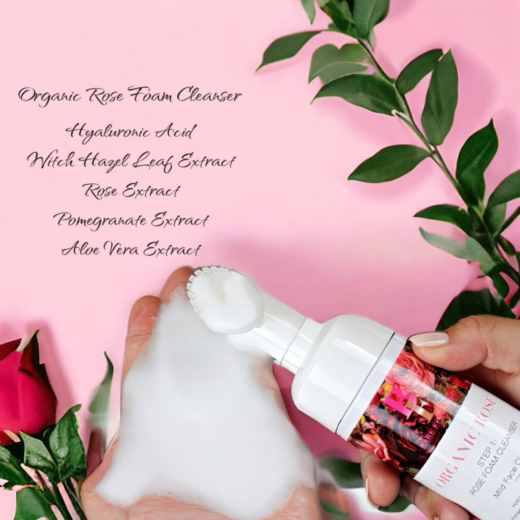 Foaming facial cleanser with natural green leaves on pink background.