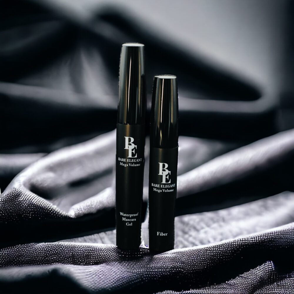 Two sleek black cosmetic tubes on a silky dark fabric background.