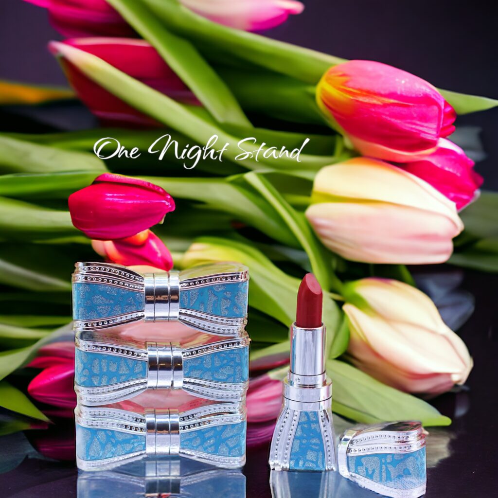 Lipstick and perfume with tulips in the background.