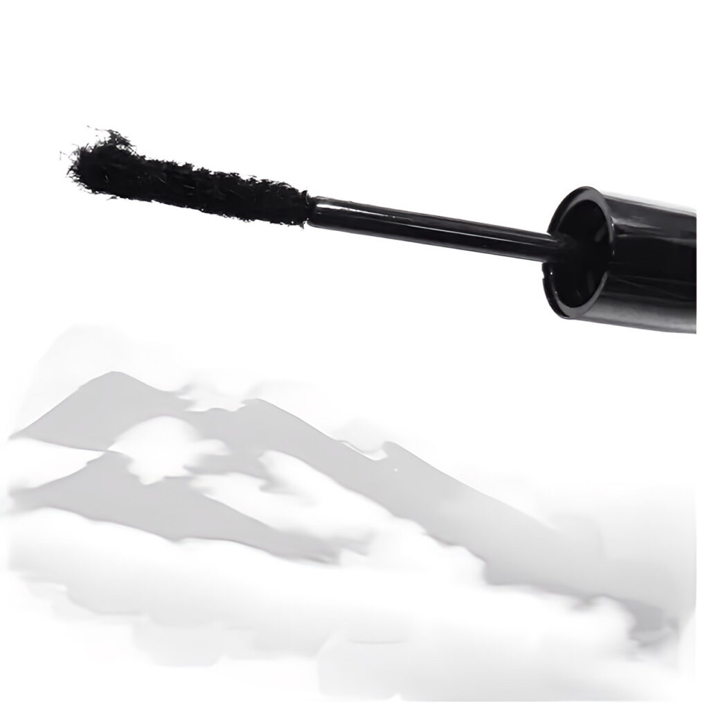 Black mascara wand with smudged mascara marks on white background.