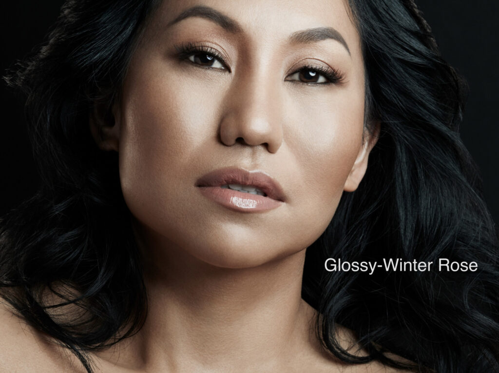 Close-up portrait of a woman with flawless makeup and glossy lips.